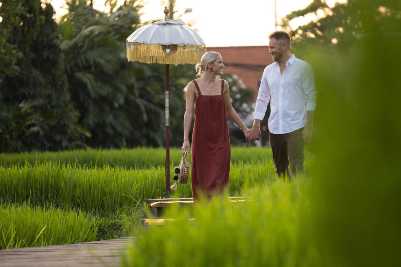 Alaya Resort Ubud Exteriér fotografie A couple walking through the rice fields at The Oberoi, Bali